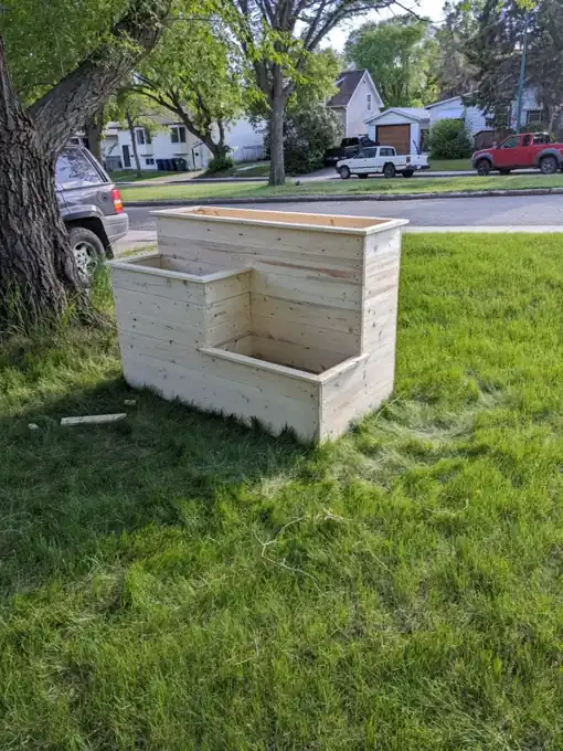 Three-level pine garden planter photographed on a lawn