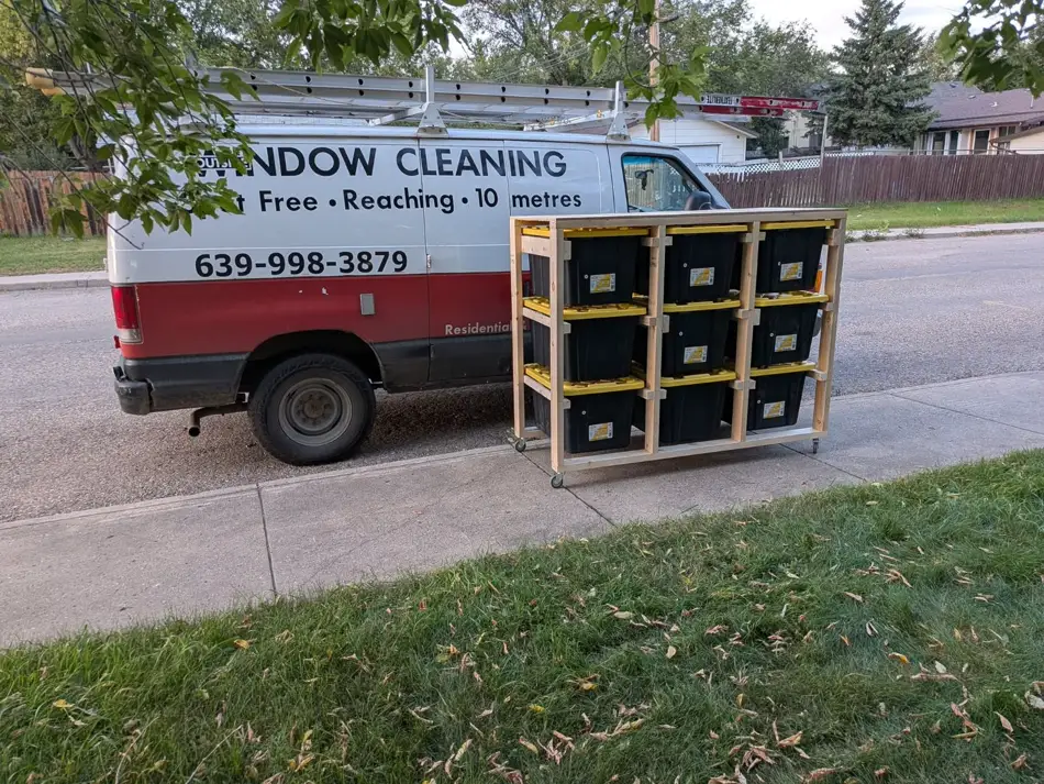 Three-wide, three-high tote tower with nine black and yellow totes beside the WCI van
